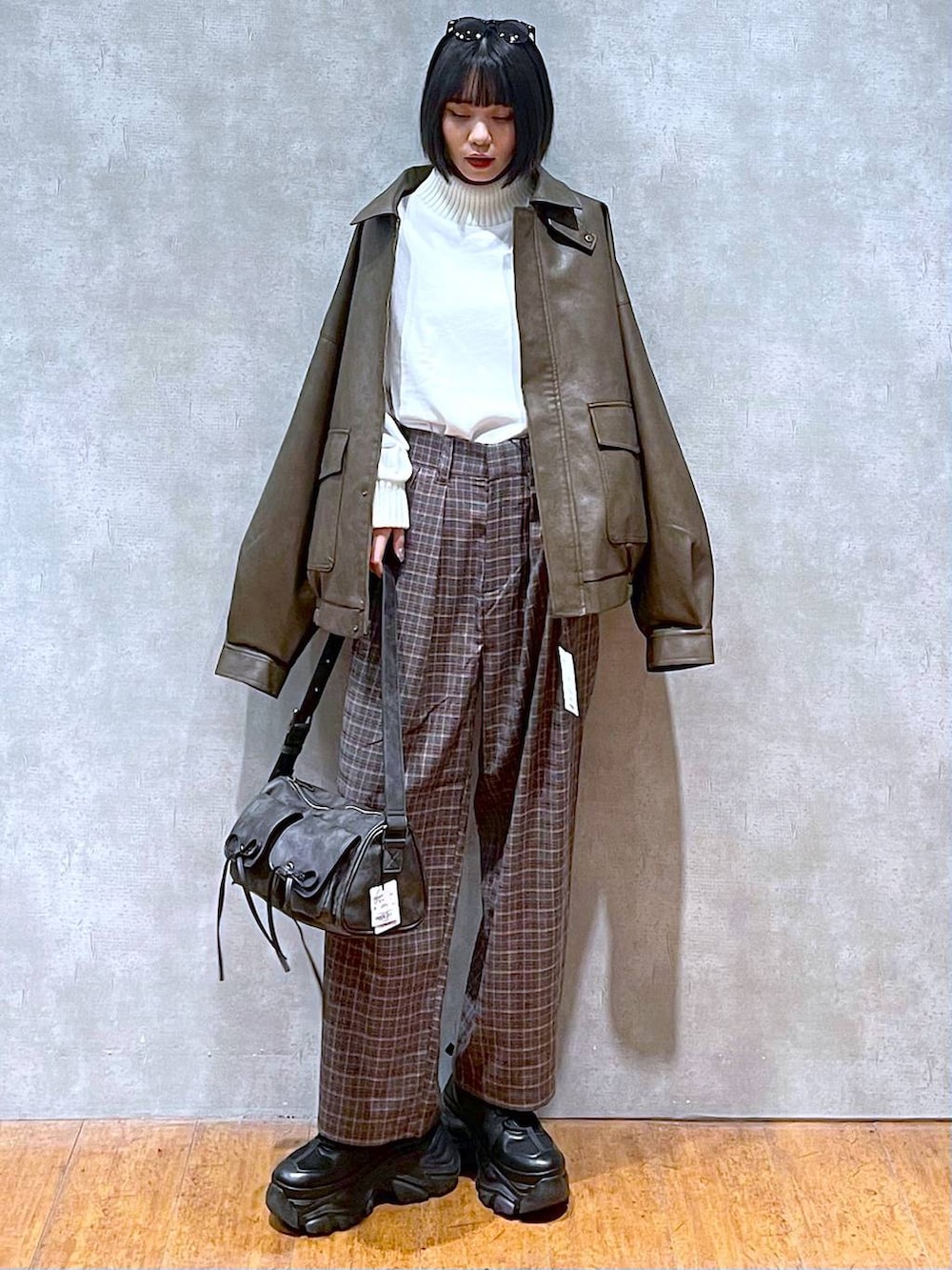 ブラック系のスニーカー、ブラック系のショルダーバッグ、ブラウン系のブルゾンを着用したレディースの秋コーディネートの10枚目の写真