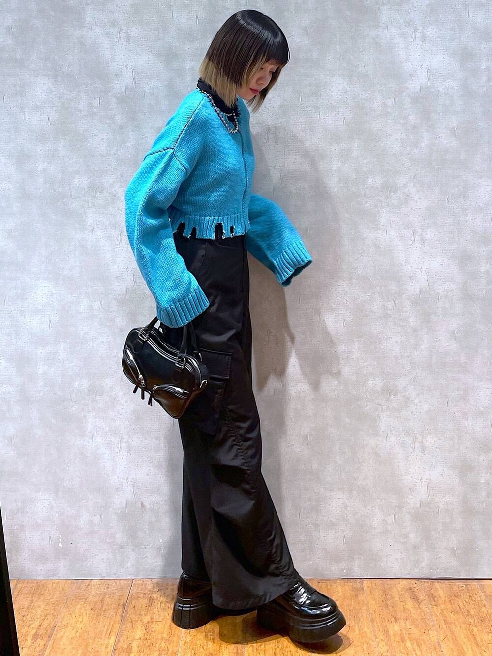 ブラック系のTシャツ/カットソー、グリーン系のニット/セーター、ブラック系のその他パンツを着用したレディースの冬コーディネートの5枚目の写真