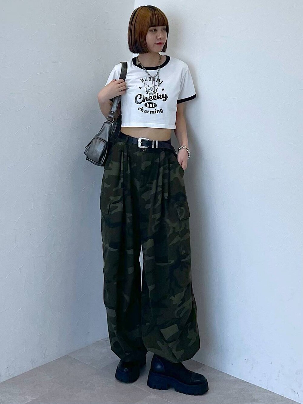 ブラック系のブーツ、グリーン系のカーゴパンツ、シルバー系のブレスレットを着用したレディースの夏コーディネートの6枚目の写真