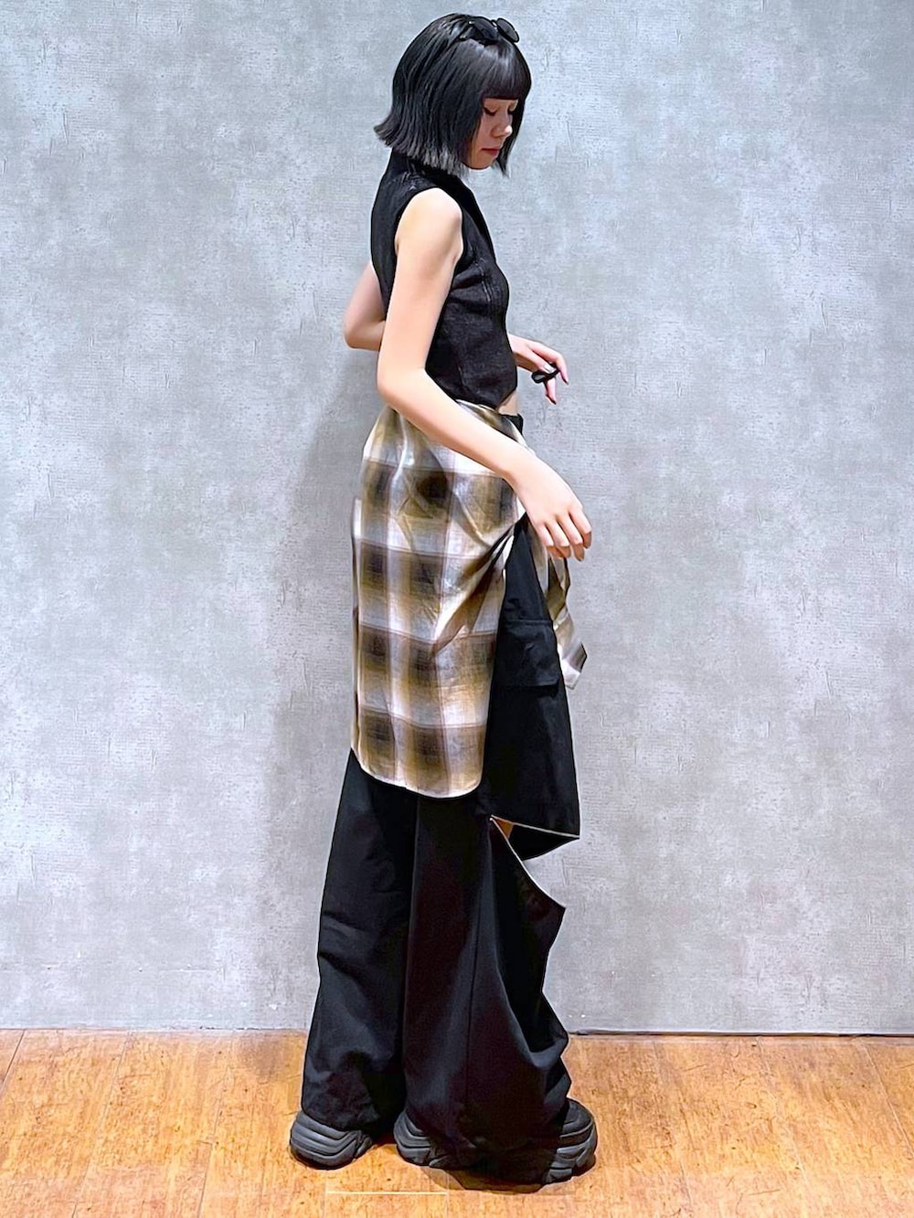 ブラック系のスニーカー、ブラック系のニット/セーター、ブラック系のカーゴパンツを着用したレディースの秋コーディネートの5枚目の写真