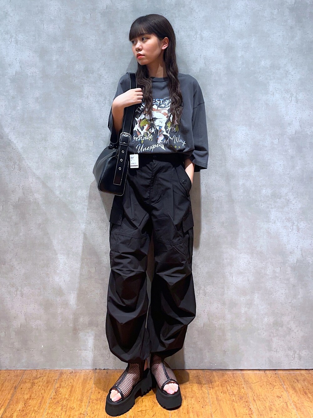 グレー系のTシャツ/カットソー、ブラック系のショルダーバッグ、ブラック系のスラックスを着用したレディースの夏コーディネートの2枚目の写真