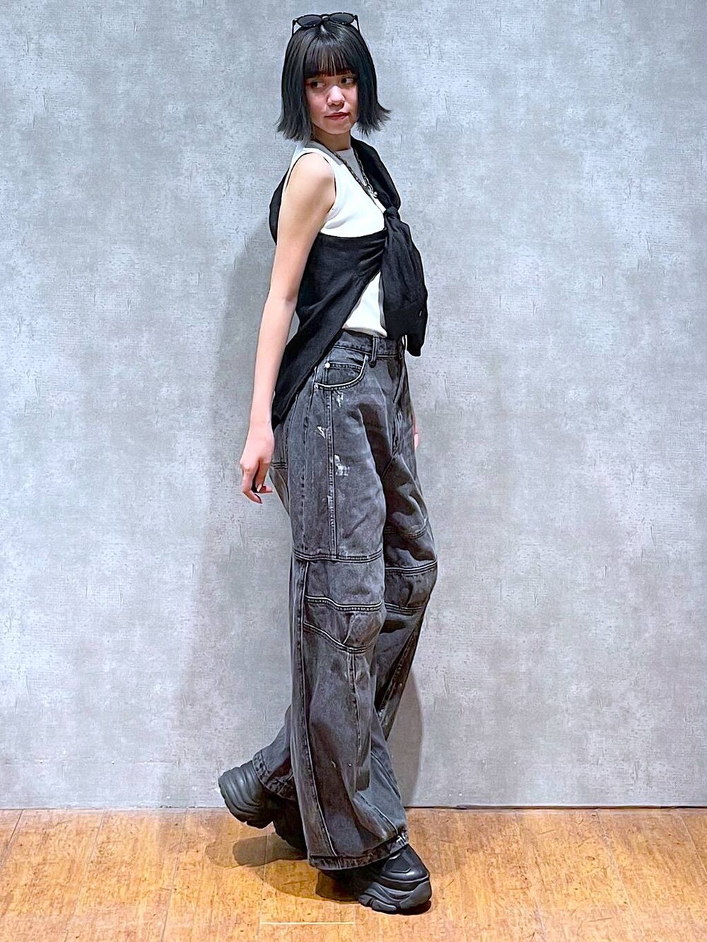 ブラック系のスニーカー、ホワイト系のタンクトップ、ブラック系のデニムパンツを着用したレディースの夏コーディネートの8枚目の写真