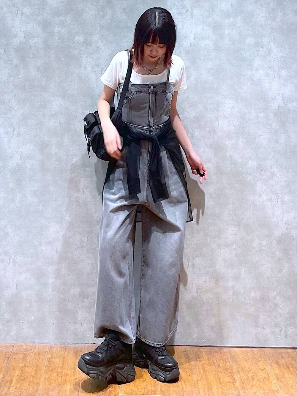 ブラック系のショルダーバッグ、ブラック系のサロペット/オーバーオール、ブラック系のスニーカーを着用したレディースの春コーディネートの3枚目の写真