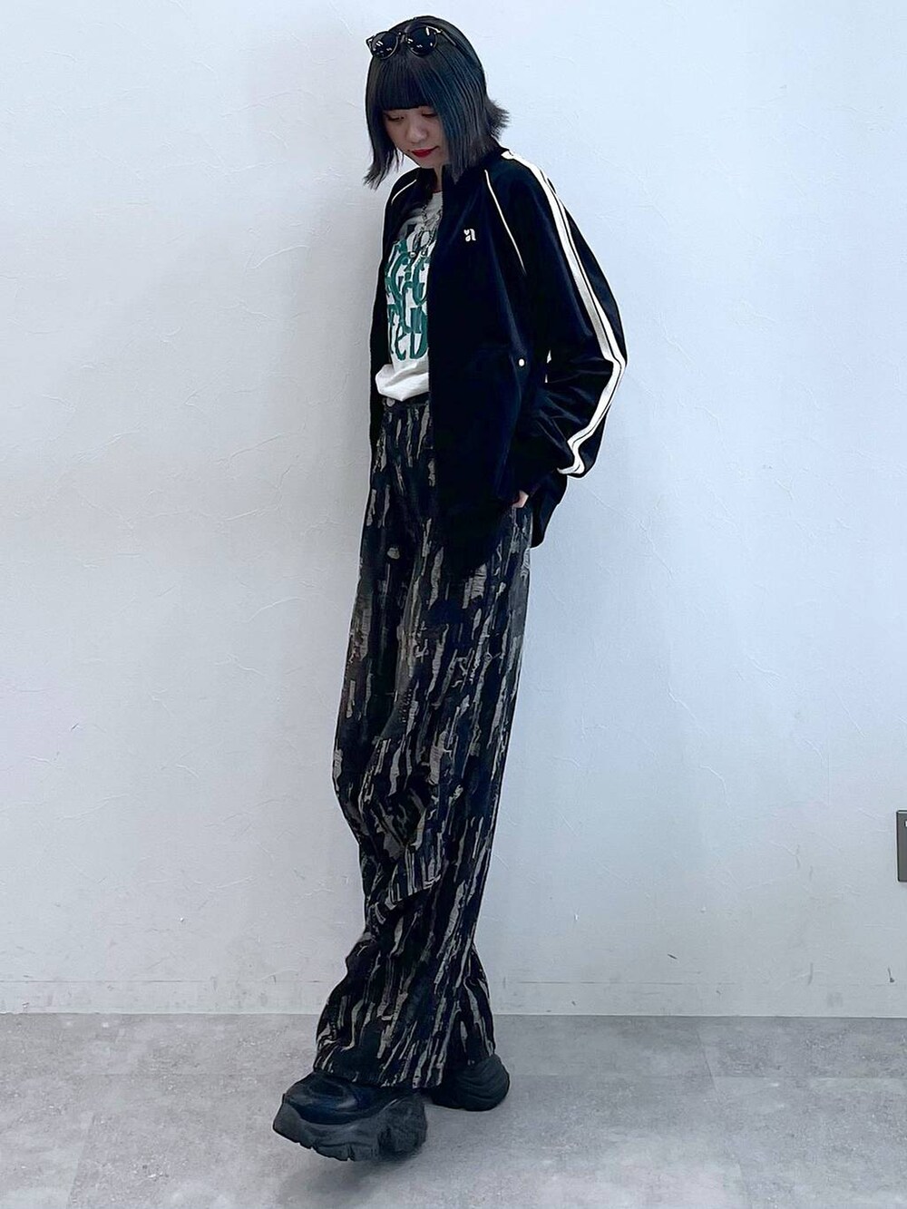 ブラック系のスニーカー、ブラック系のデニムパンツ、ブラック系のジャージを着用したレディースの秋コーディネートの3枚目の写真