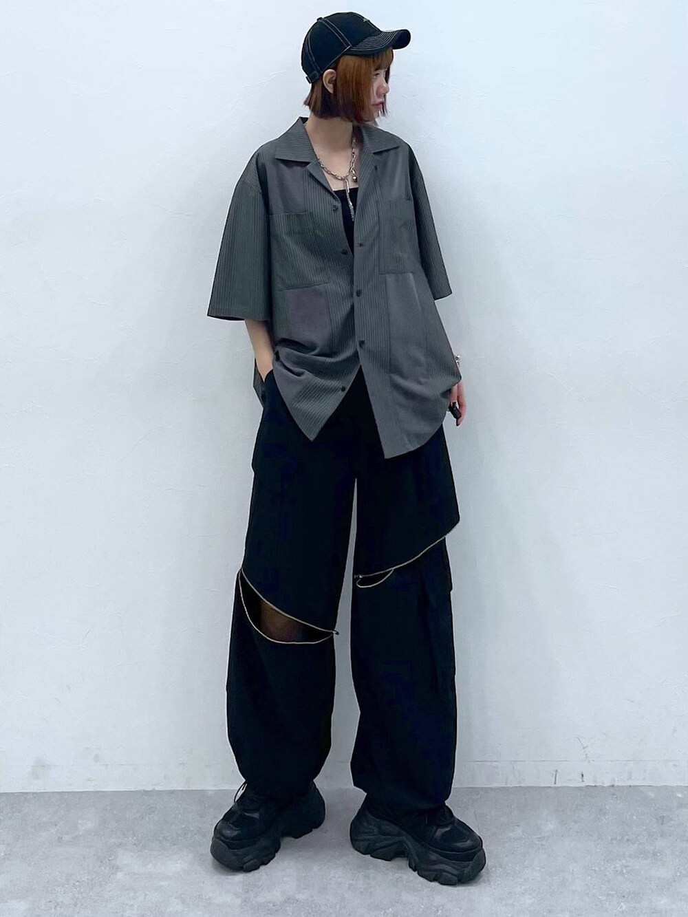 ブラック系のスニーカー、ブラック系のキャミソール、ブラック系のカーゴパンツを着用したレディースの夏コーディネートの3枚目の写真