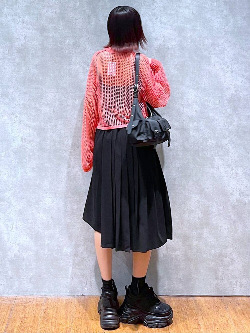 ブラック系のショルダーバッグ、ピンク系のカーディガン/ボレロ、ブラック系のキャミソールを着用したレディースの春コーディネートの6枚目の写真