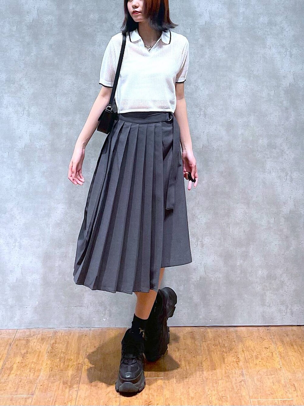 ブラック系のスニーカー、グレー系のスカート、ホワイト系のキャミソールを着用したレディースの夏コーディネートの4枚目の写真