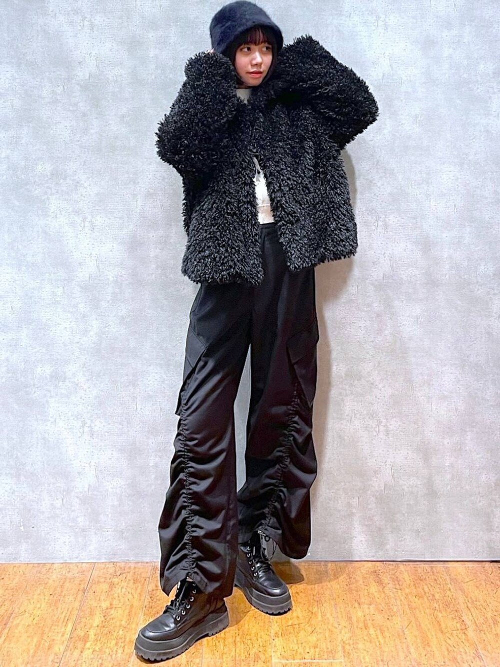 ブラック系のブーツ、ベージュ系のニット/セーター、ブラック系のその他アウターを着用したレディースの冬コーディネートの4枚目の写真