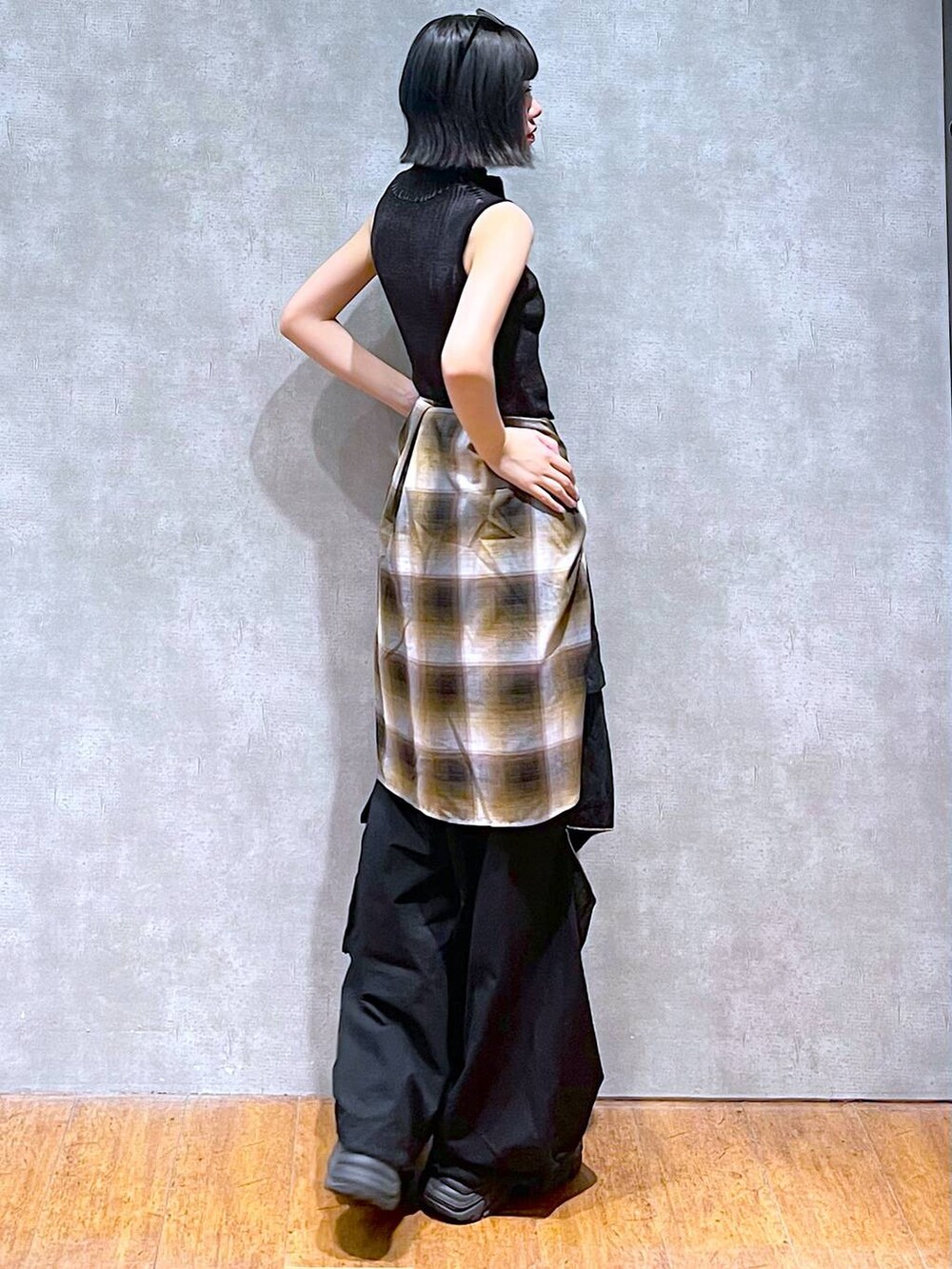 ブラック系のスニーカー、ブラック系のニット/セーター、ブラック系のカーゴパンツを着用したレディースの秋コーディネートの6枚目の写真