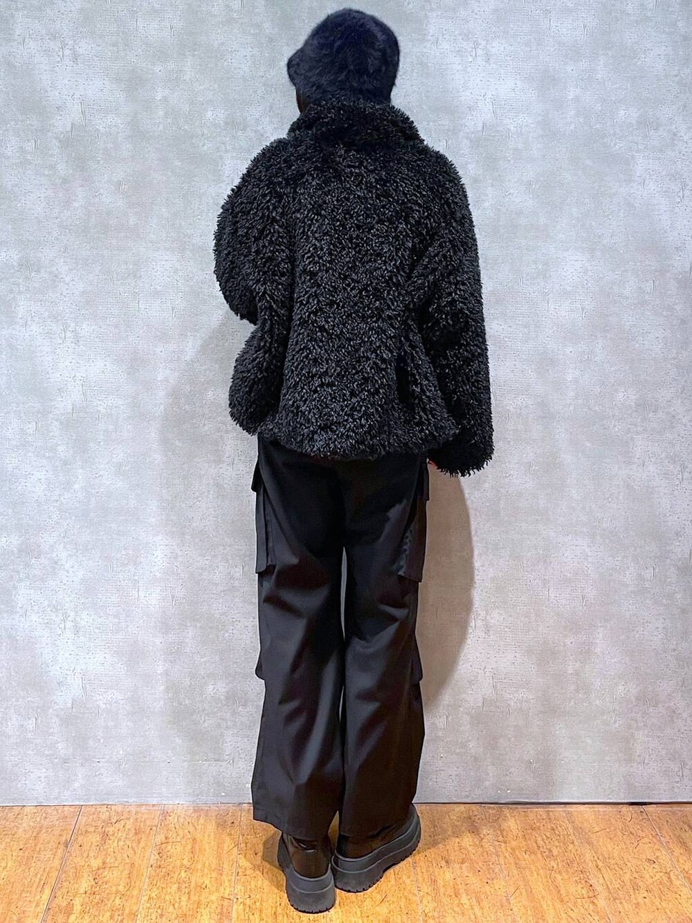 ブラック系のブーツ、ベージュ系のニット/セーター、ブラック系のその他アウターを着用したレディースの冬コーディネートの5枚目の写真