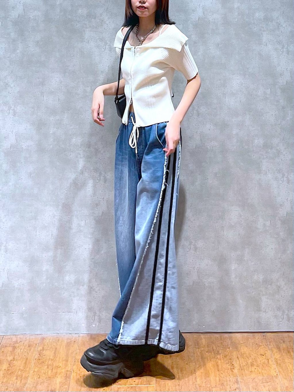 ブラック系のスニーカー、ホワイト系のニット/セーター、ホワイト系のキャミソールを着用したレディースの夏コーディネートの7枚目の写真