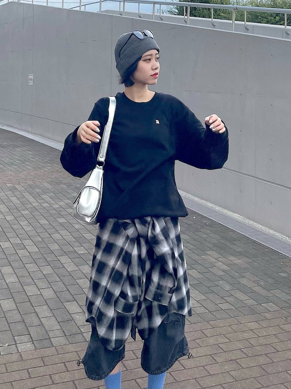 ブラック系のスニーカー、ブラック系のシャツ/ブラウス、ブラック系のデニムパンツを着用したレディースの秋コーディネートの3枚目の写真