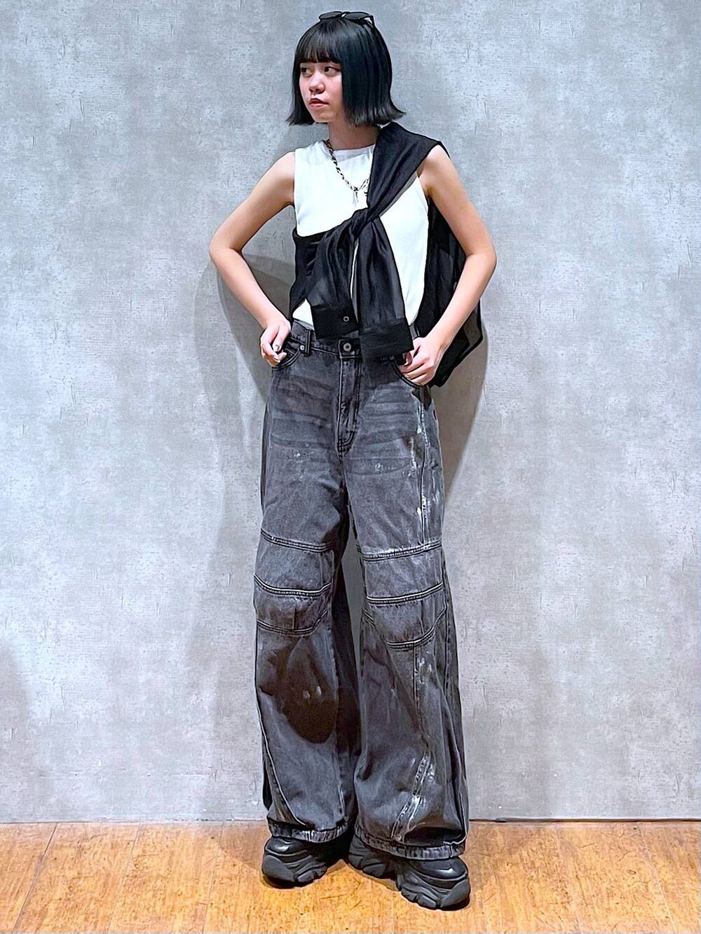 ブラック系のスニーカー、ホワイト系のタンクトップ、ブラック系のデニムパンツを着用したレディースの夏コーディネートの5枚目の写真