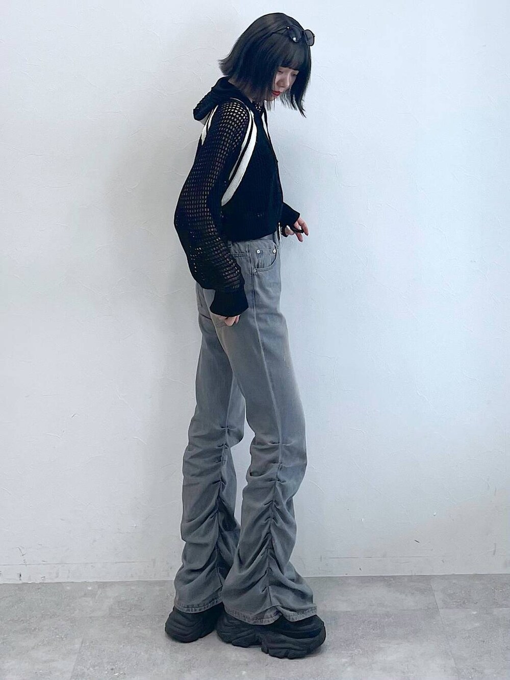 ブラック系のスニーカー、ブラック系のキャミソール、ブルー系のデニムパンツを着用したレディースの夏コーディネートの3枚目の写真