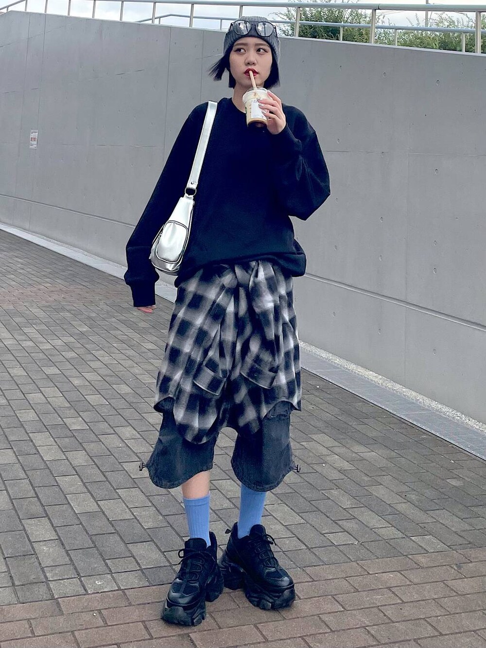 ブラック系のスニーカー、ブラック系のシャツ/ブラウス、ブラック系のデニムパンツを着用したレディースの秋コーディネートの8枚目の写真