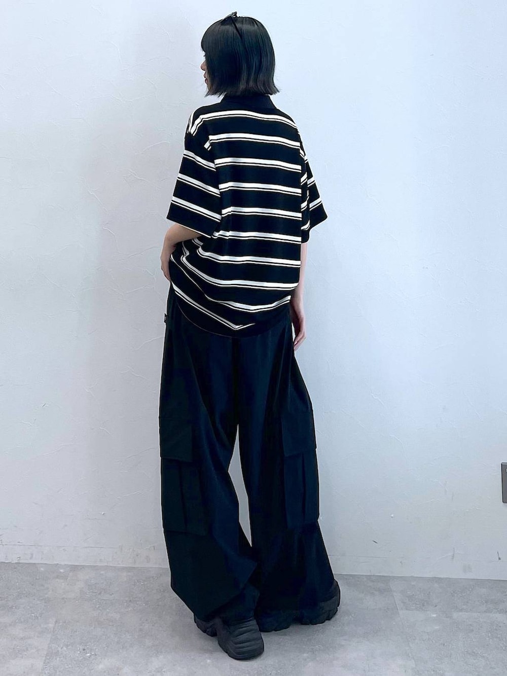 ブラック系のスニーカー、ブラック系のカーゴパンツ、ブラック系のTシャツ/カットソーを着用したレディースの夏コーディネートの4枚目の写真