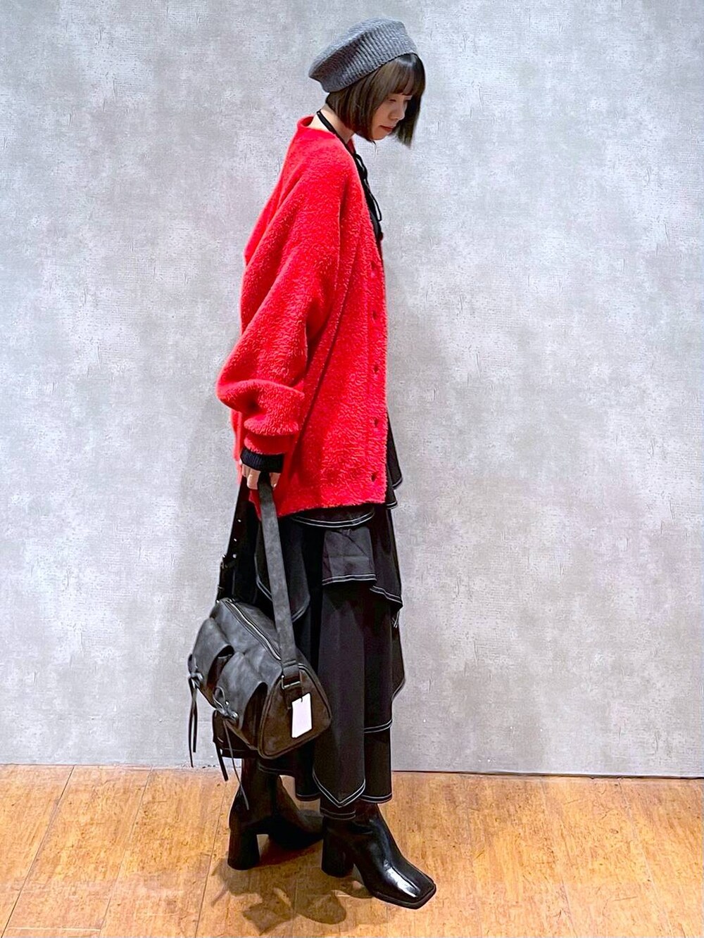 ブラック系のショルダーバッグ、ブラック系のブーツ、ブラック系のスカートを着用したレディースの秋コーディネートの4枚目の写真