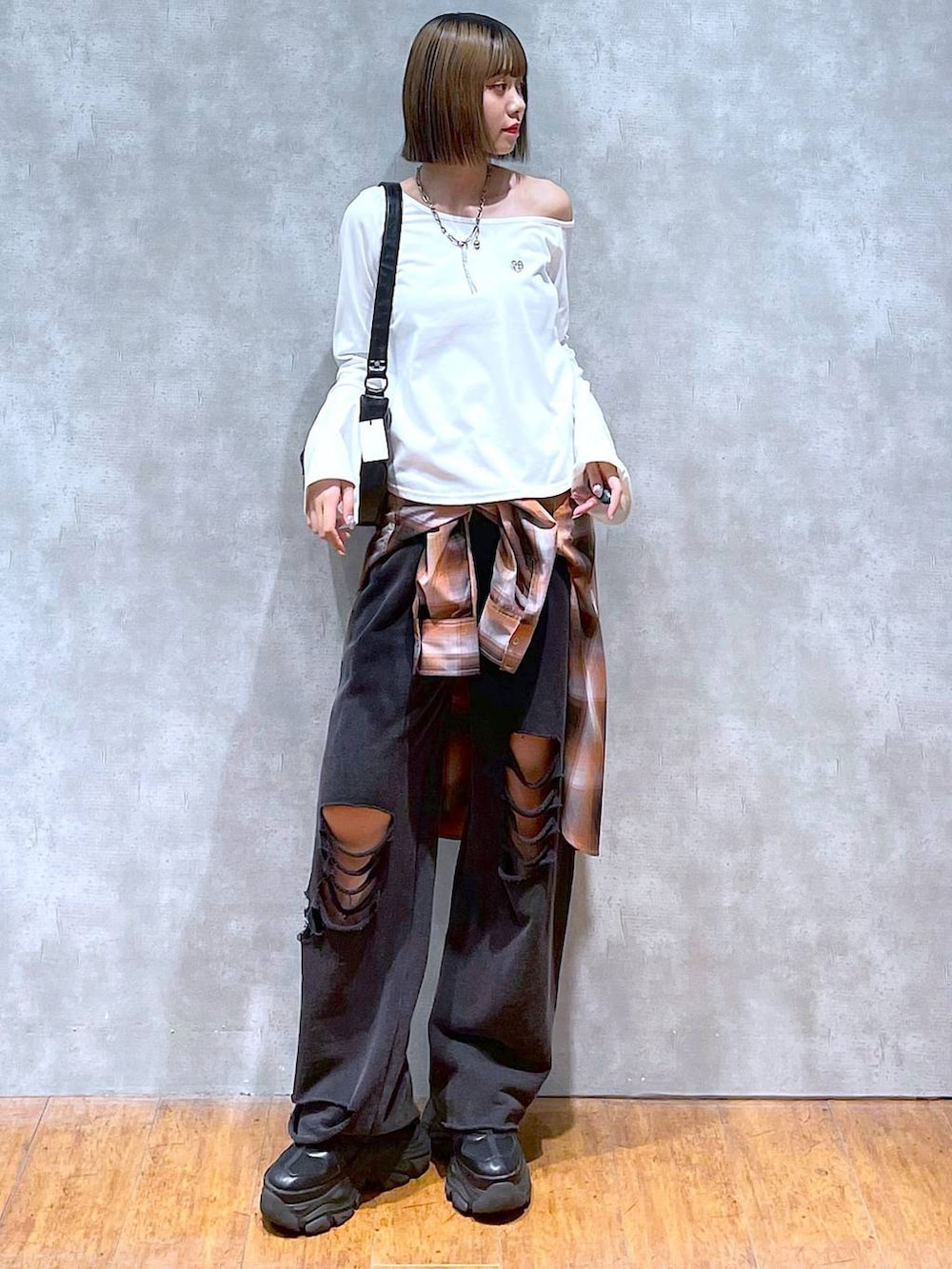 ブラック系のスニーカー、ブラック系のその他パンツ、オレンジ系のシャツ/ブラウスを着用したレディースの秋コーディネートの3枚目の写真