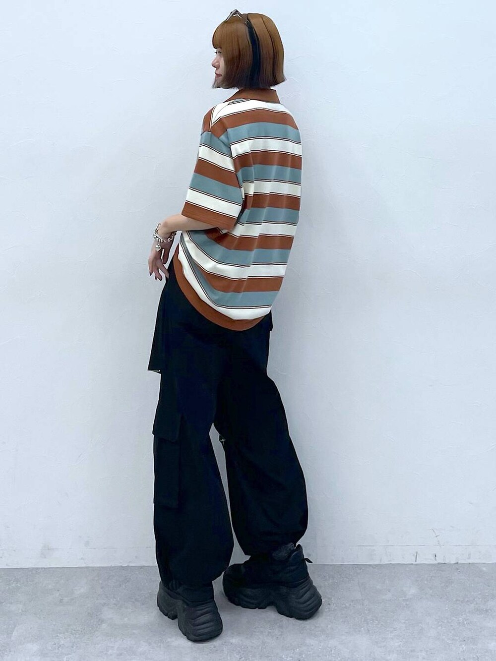 ブラック系のスニーカー、ブラック系のカーゴパンツ、ブラウン系のTシャツ/カットソーを着用したレディースの夏コーディネートの5枚目の写真