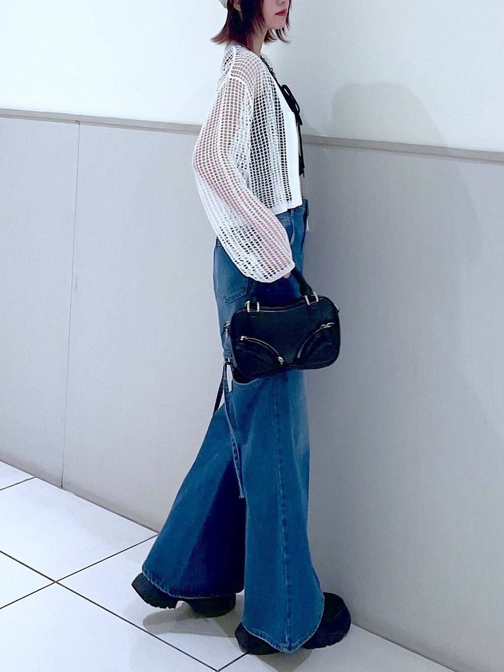 ホワイト系のカーディガン/ボレロ、ブラック系のタンクトップ、ブルー系のデニムパンツを着用したレディースの春コーディネートの8枚目の写真