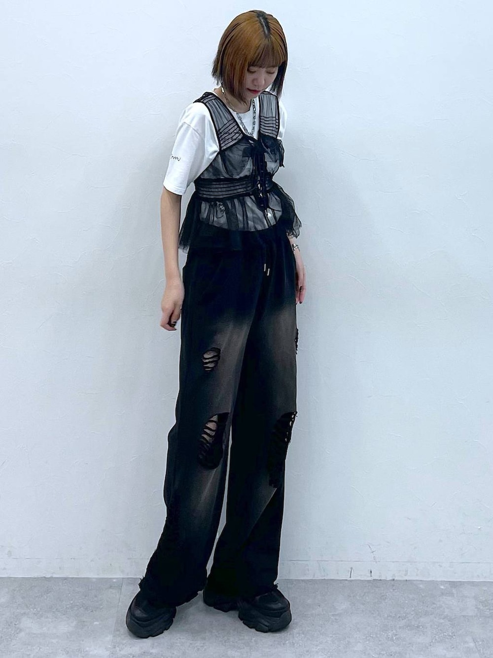 ブラック系のスニーカー、ブラック系のベスト、ホワイト系のTシャツ/カットソーを着用したレディースの夏コーディネートの2枚目の写真