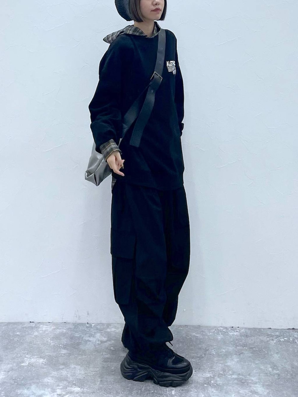 ブラック系のスニーカー、ブラック系のスウェット、シルバー系のトートバッグを着用したレディースの秋コーディネートの5枚目の写真