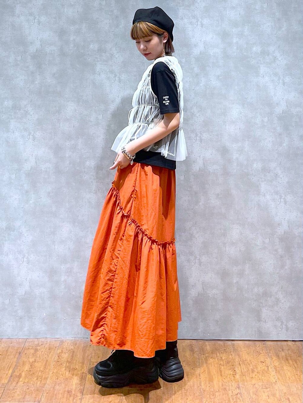 ブラック系のスニーカー、ブラック系のハンドバッグ、ブラック系のTシャツ/カットソーを着用したレディースの夏コーディネートの3枚目の写真