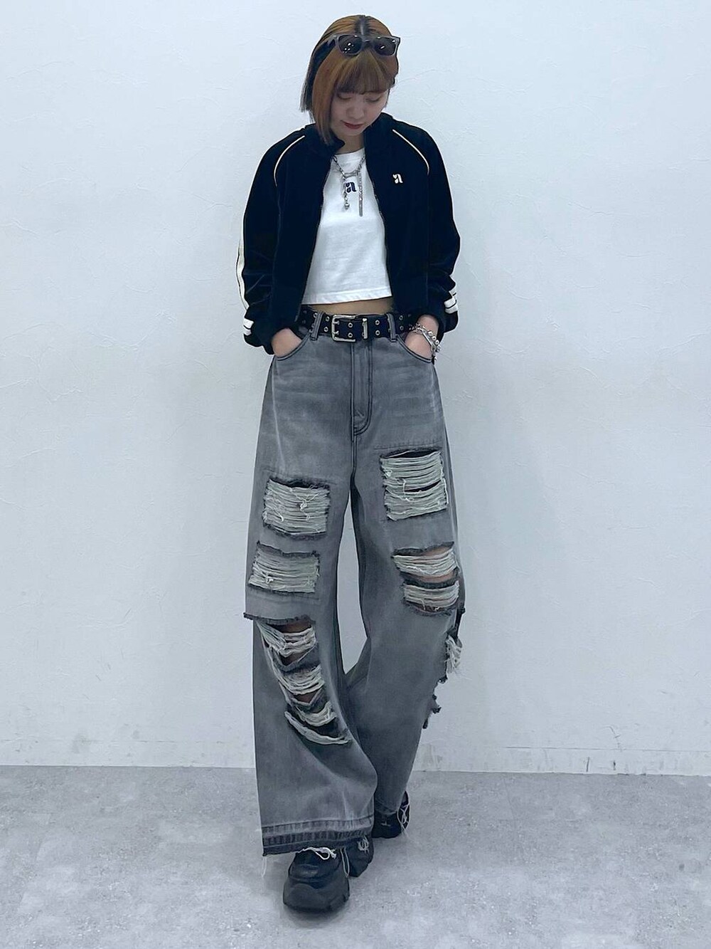 ブラック系のデニムパンツ、ブラック系のスニーカー、ホワイト系のTシャツ/カットソーを着用したレディースの夏コーディネートの2枚目の写真