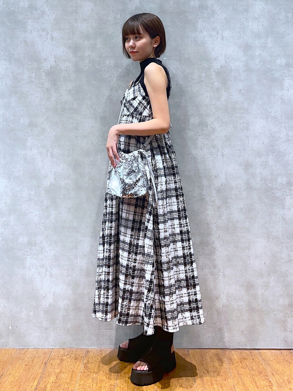 ブラック系のTシャツ/カットソー、ホワイト系のワンピース、シルバー系のショルダーバッグを着用したレディースの夏コーディネートの2枚目の写真