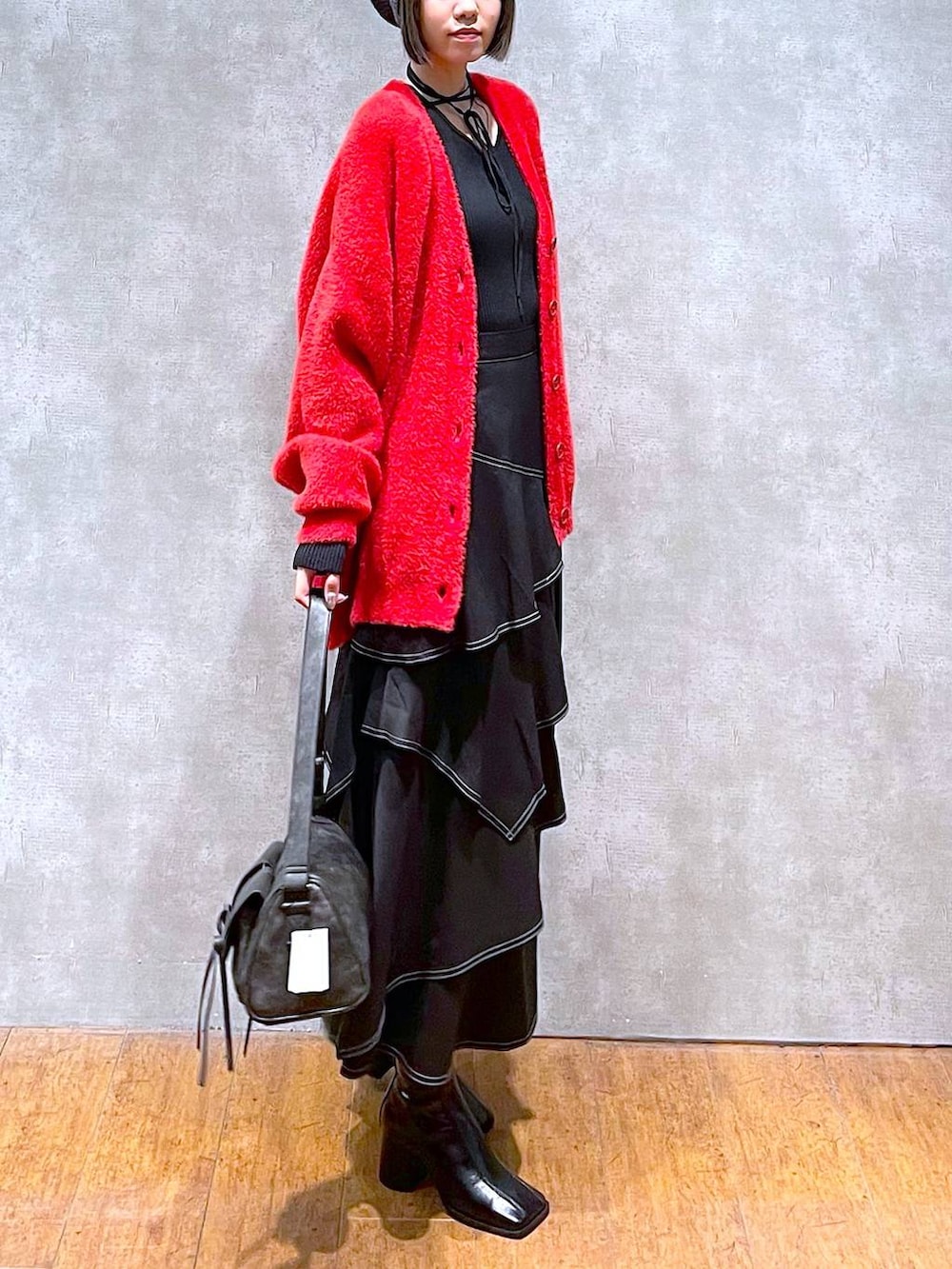 ブラック系のショルダーバッグ、ブラック系のブーツ、ブラック系のスカートを着用したレディースの秋コーディネートの6枚目の写真