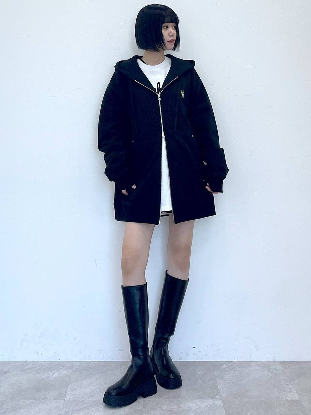 ブラック系のパーカー、ブラック系のブーツ、ブラック系のその他パンツを着用したレディースの冬コーディネートの4枚目の写真