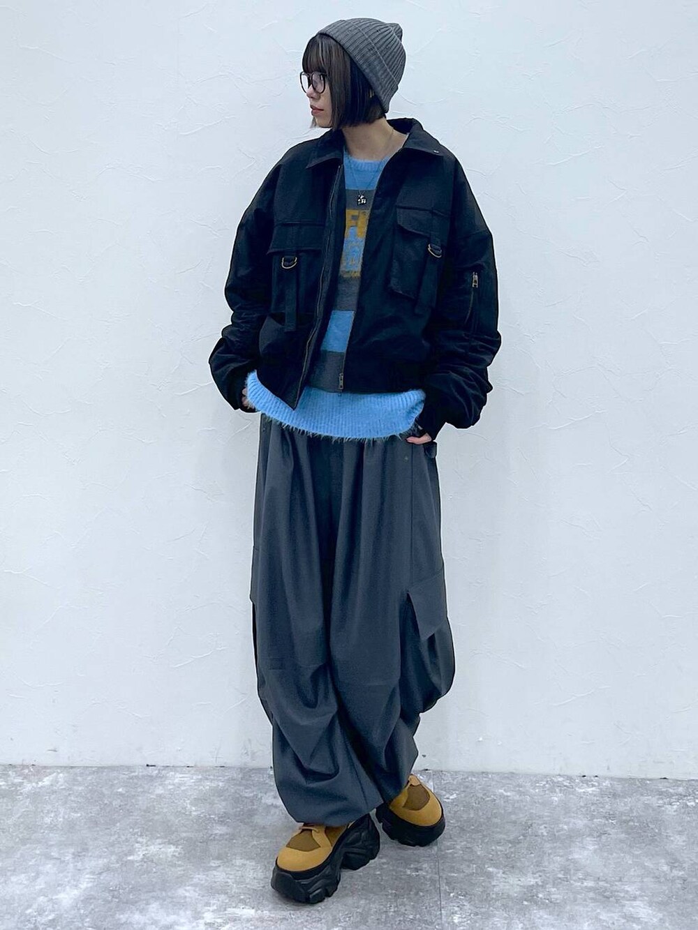 ブラウン系のブーツ、ブラック系のブルゾン、グレー系のカーゴパンツを着用したレディースの秋コーディネートの2枚目の写真