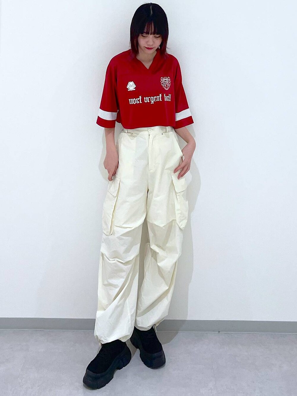 ホワイト系のカーゴパンツ、ブラック系のブーツ、レッド系のTシャツ/カットソーを着用したレディースの春コーディネートの2枚目の写真