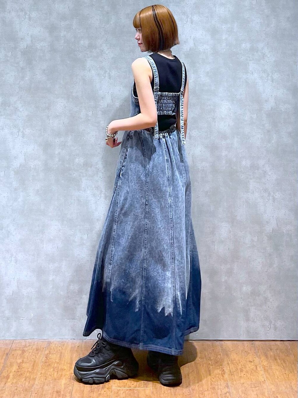 ブラック系のスニーカー、ブルー系のワンピース、ブラック系のハンドバッグを着用したレディースの夏コーディネートの4枚目の写真