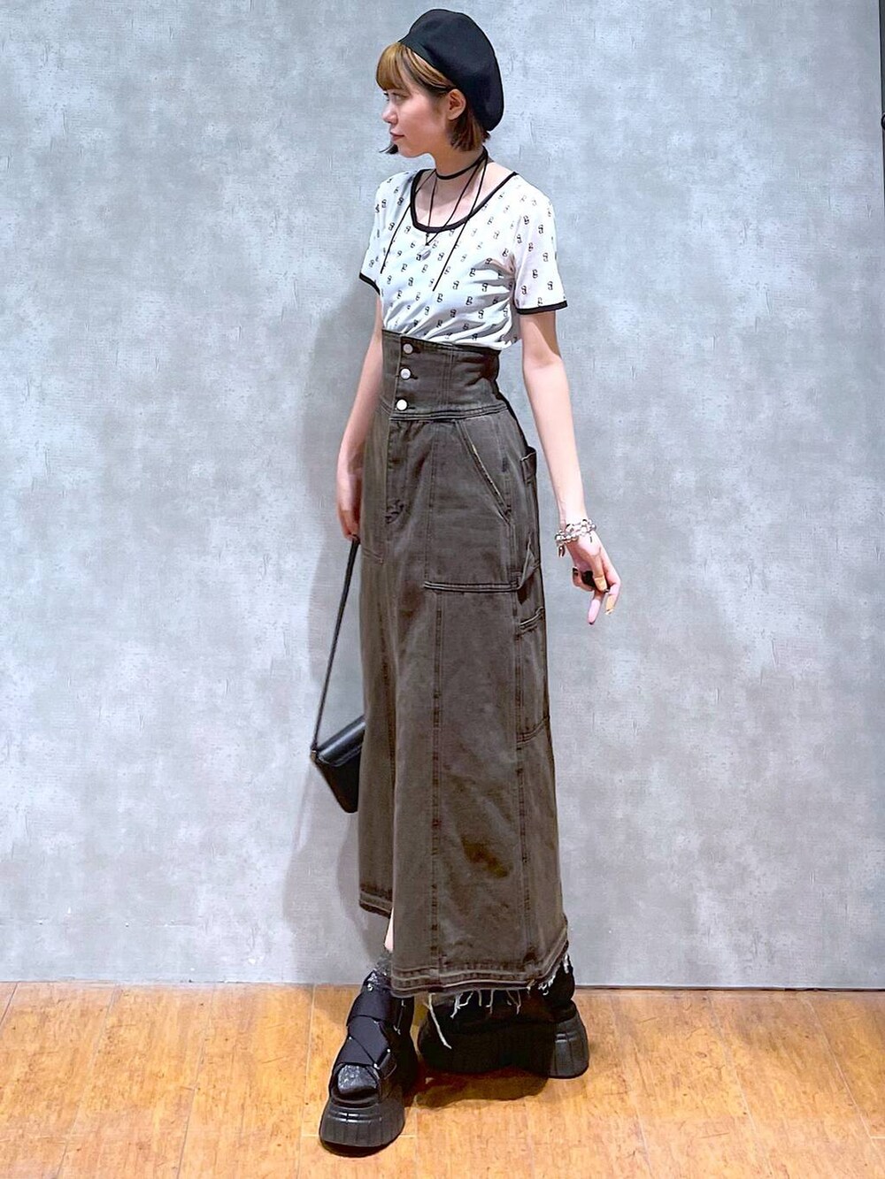 ブラック系のスニーカー、ブラック系のデニムスカート、ブラック系のハンドバッグを着用したレディースの夏コーディネートの3枚目の写真