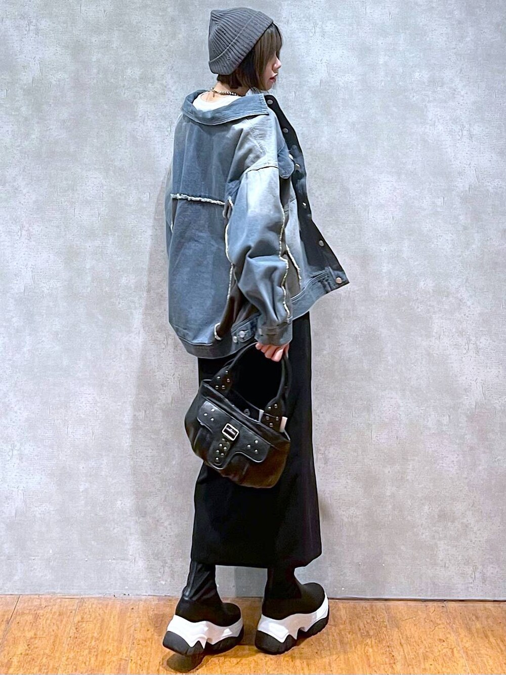 ブルー系のブルゾン、ブラック系のハンドバッグ、ホワイト系のTシャツ/カットソーを着用したレディースの秋コーディネートの2枚目の写真