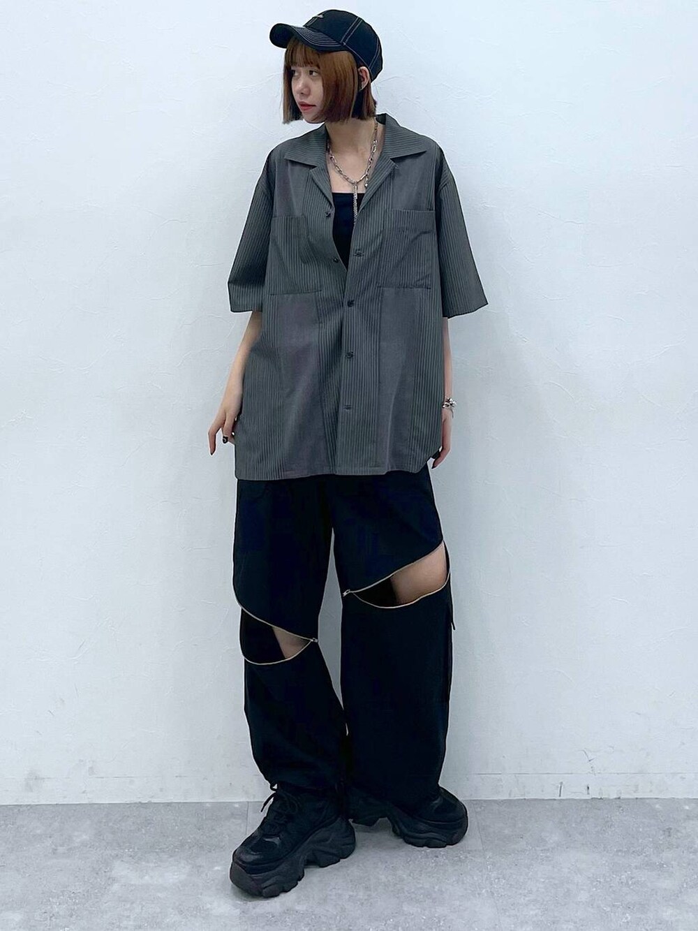 ブラック系のスニーカー、ブラック系のキャミソール、ブラック系のカーゴパンツを着用したレディースの夏コーディネートの2枚目の写真