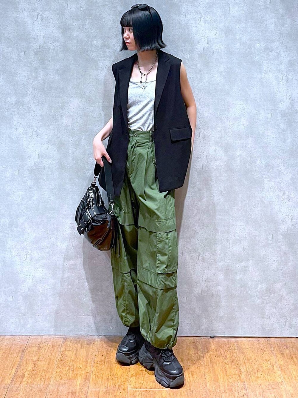 ブラック系のスニーカー、グリーン系のその他パンツ、ブラック系のショルダーバッグを着用したレディースの夏コーディネートの3枚目の写真