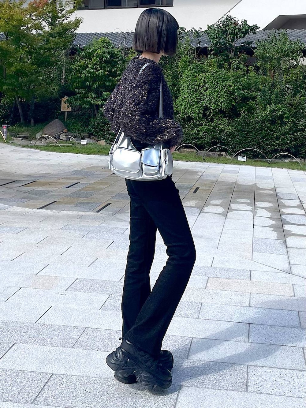 ブラック系のスニーカー、シルバー系のショルダーバッグ、ブラック系のニット/セーターを着用したレディースの秋コーディネートの7枚目の写真