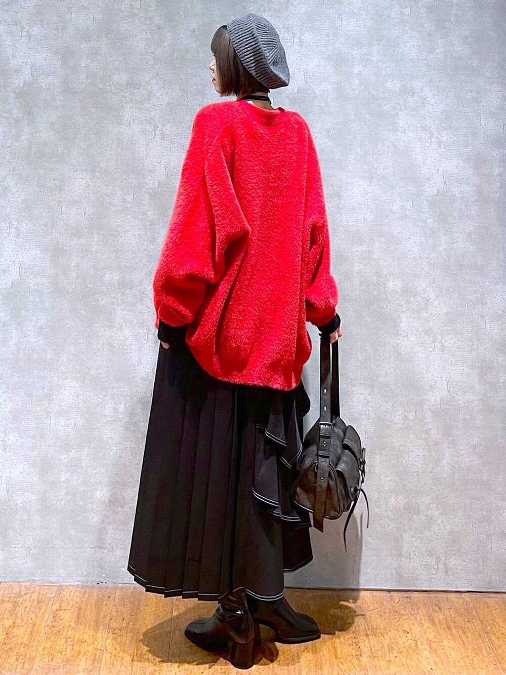 ブラック系のショルダーバッグ、ブラック系のブーツ、ブラック系のスカートを着用したレディースの秋コーディネートの3枚目の写真