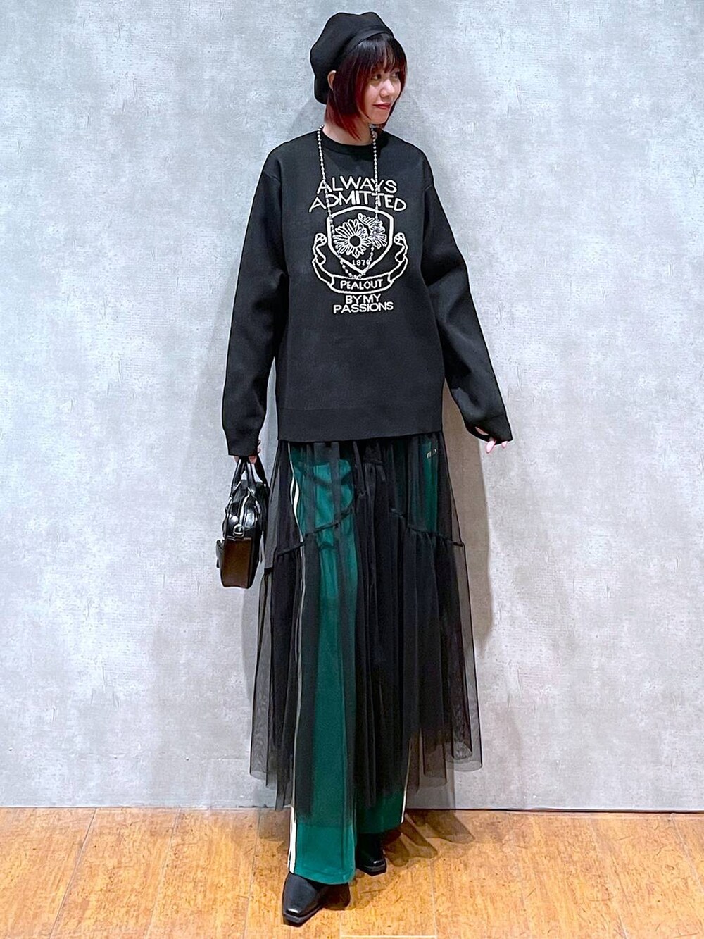 グリーン系のその他パンツ、ブラック系のニット/セーター、ブラック系のボストンバッグを着用したレディースの冬コーディネートの2枚目の写真