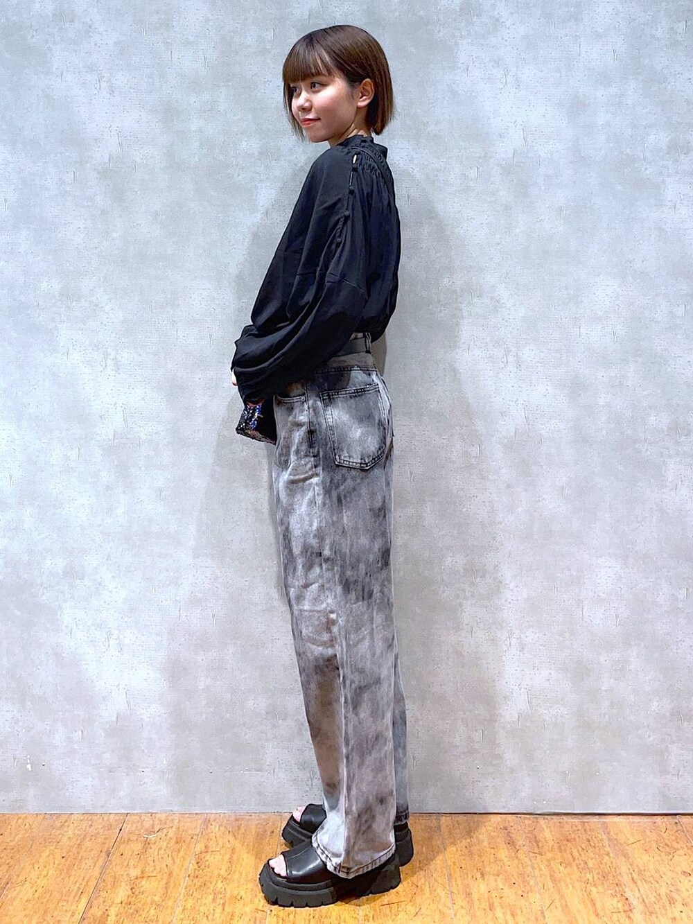 ブラック系のサンダル、ブラック系のショルダーバッグ、ブラック系のデニムパンツを着用したレディースの夏コーディネートの2枚目の写真