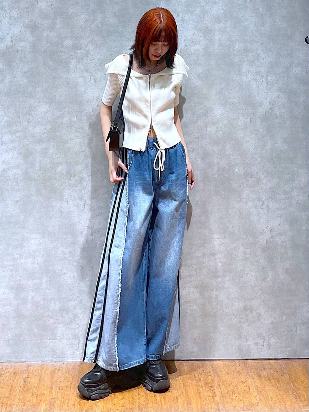 ブラック系のスニーカー、ホワイト系のニット/セーター、ホワイト系のキャミソールを着用したレディースの夏コーディネートの2枚目の写真