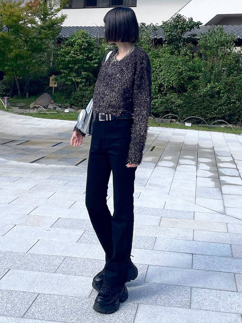 ブラック系のスニーカー、シルバー系のショルダーバッグ、ブラック系のニット/セーターを着用したレディースの秋コーディネートの3枚目の写真