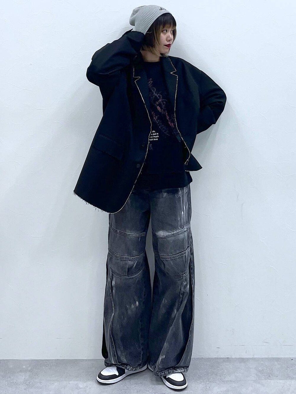 ブラック系のテーラードジャケット、ブラック系のデニムパンツ、ブラック系のスウェットを着用したレディースの冬コーディネートの4枚目の写真