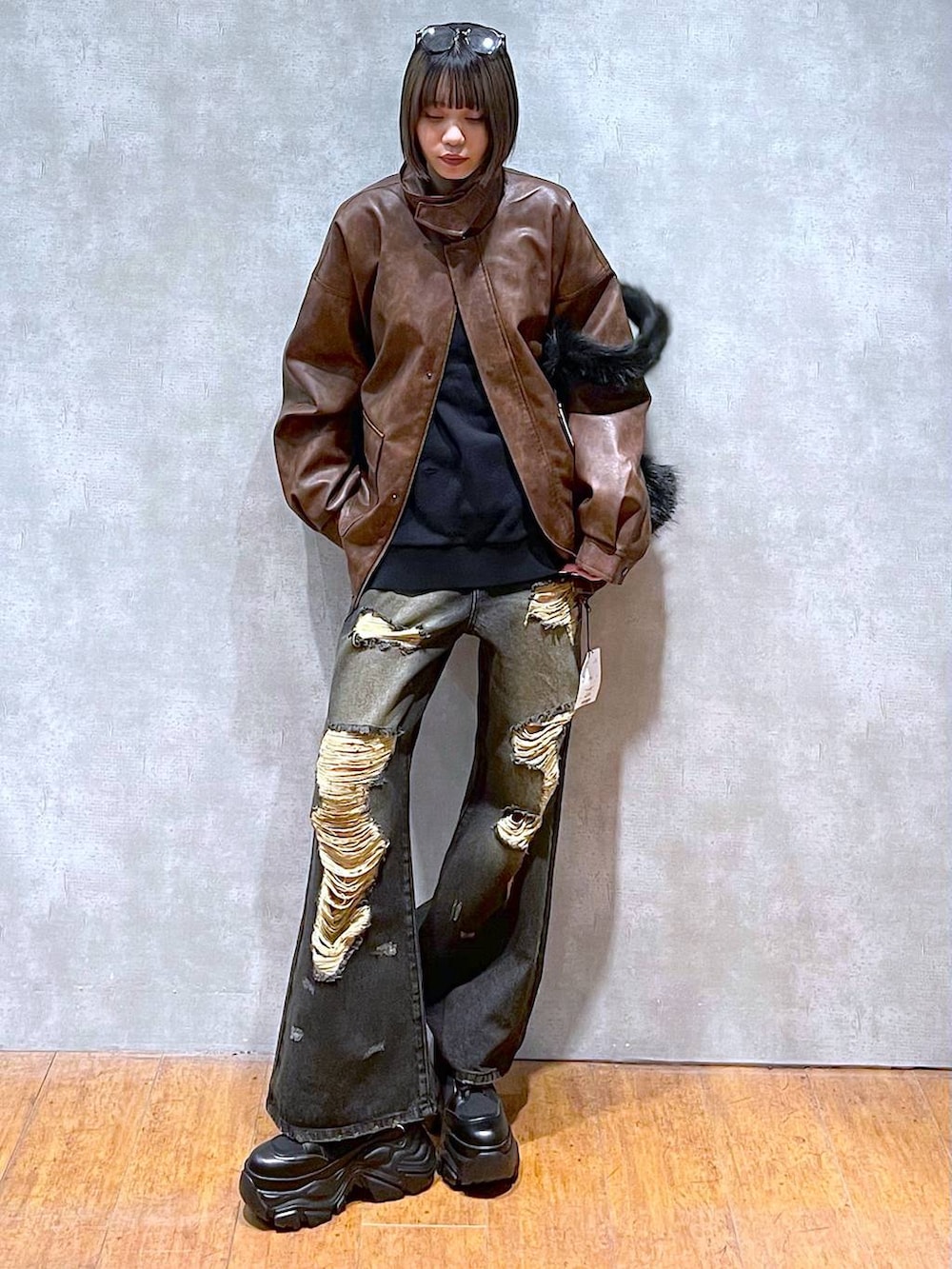 ブラウン系のブルゾン、ブラック系のブーツ、グレー系のスウェットを着用したレディースの秋コーディネートの8枚目の写真