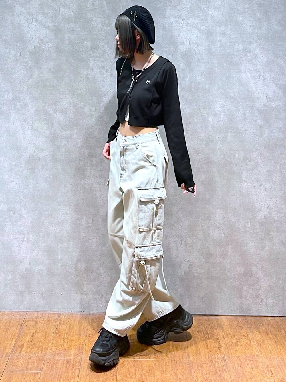 ブラック系のスニーカー、ブルー系のデニムパンツ、ブラック系のショルダーバッグを着用したレディースの秋コーディネートの2枚目の写真