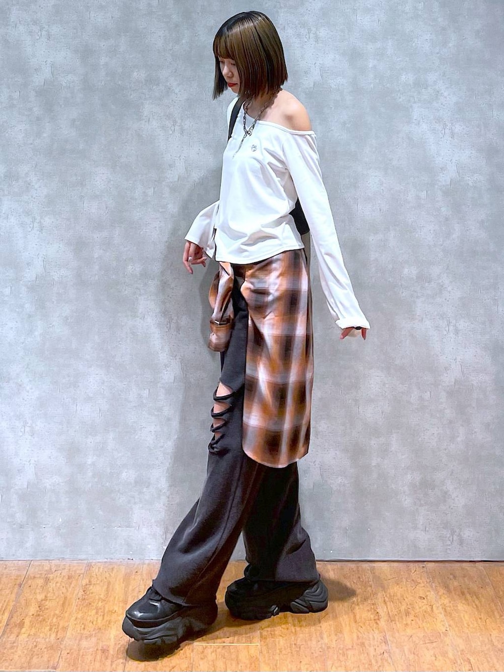 ブラック系のスニーカー、ブラック系のその他パンツ、オレンジ系のシャツ/ブラウスを着用したレディースの秋コーディネートの5枚目の写真