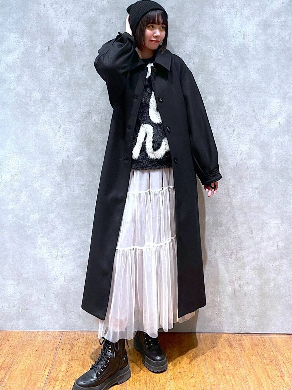 ブラック系のブーツ、ブラック系のチェスターコート、ブラック系のニット/セーターを着用したレディースの冬コーディネートの4枚目の写真