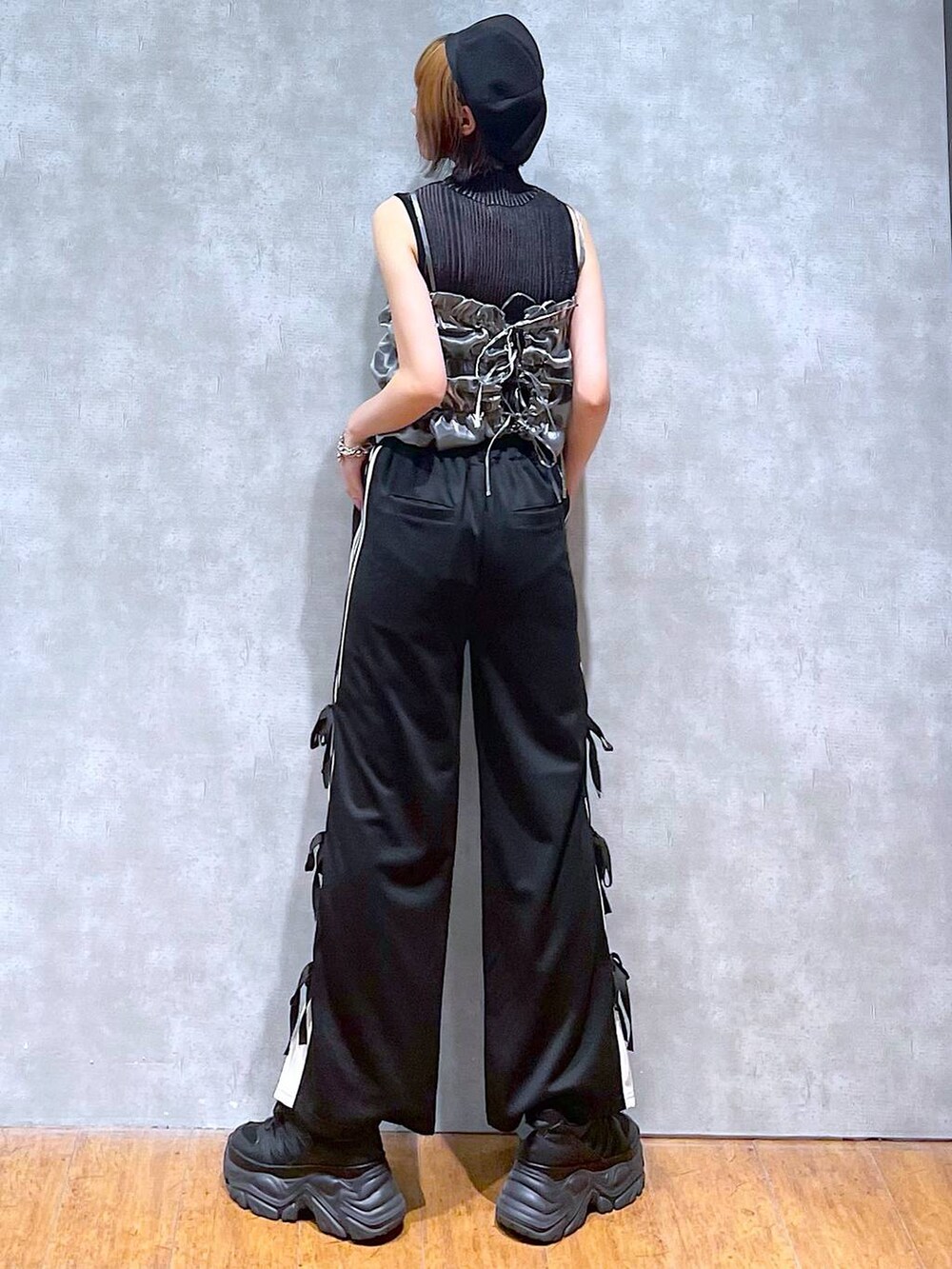 ブラック系のスニーカー、ブラック系のニット/セーター、ブラック系のその他パンツを着用したレディースの夏コーディネートの7枚目の写真